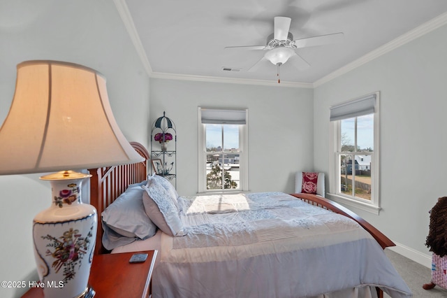 carpeted bedroom with baseboards, multiple windows, visible vents, and crown molding