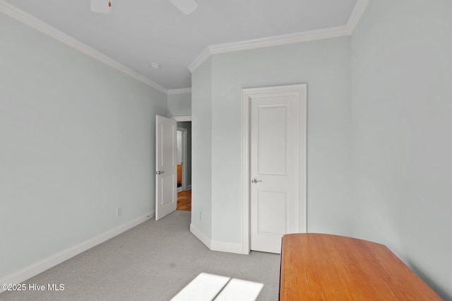 unfurnished bedroom featuring a ceiling fan, crown molding, baseboards, and carpet flooring