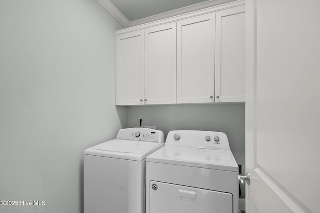 laundry room with cabinet space, washing machine and dryer, and crown molding