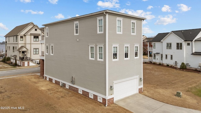 view of property exterior featuring a garage, concrete driveway, and a residential view