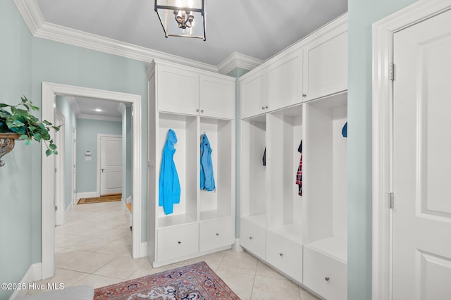 mudroom with crown molding, baseboards, and light tile patterned floors