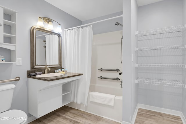 full bath featuring baseboards, toilet, shower / tub combo, wood finished floors, and vanity