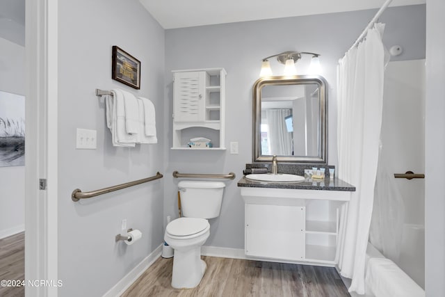 bathroom featuring toilet, vanity, baseboards, and wood finished floors