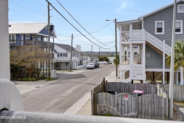 view of road with sidewalks, stairway, a residential view, and street lighting