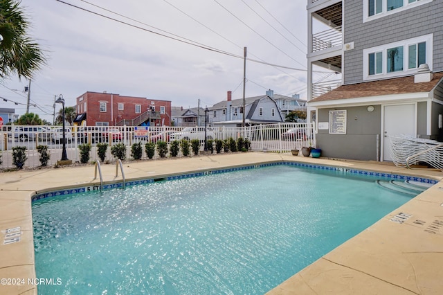 pool with a residential view and fence