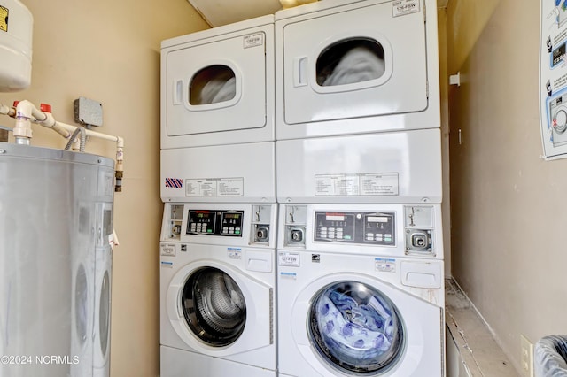 community laundry room with water heater, stacked washer / dryer, and washer and dryer