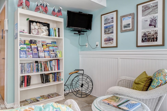 sitting room with wainscoting and tile patterned flooring