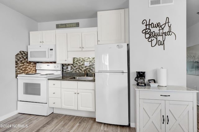 kitchen featuring light wood finished floors, visible vents, white appliances, and a sink