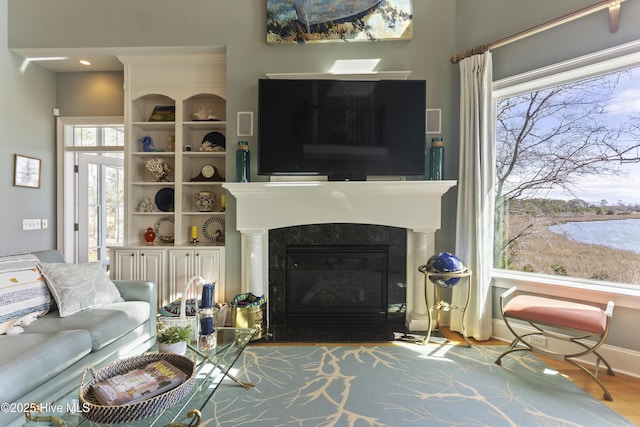 living room featuring a fireplace with flush hearth and wood finished floors