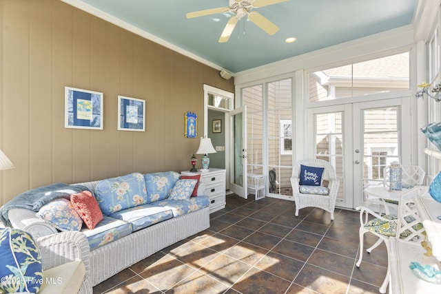 living area with french doors, dark tile patterned floors, a ceiling fan, and crown molding