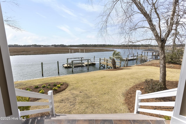 dock area with a lawn, a water view, and boat lift