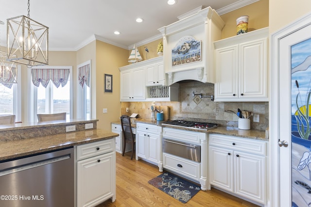 kitchen featuring light wood-type flooring, ornamental molding, white cabinets, stainless steel appliances, and a warming drawer