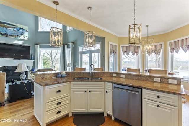 kitchen with a sink, open floor plan, dishwasher, light wood-type flooring, and a chandelier