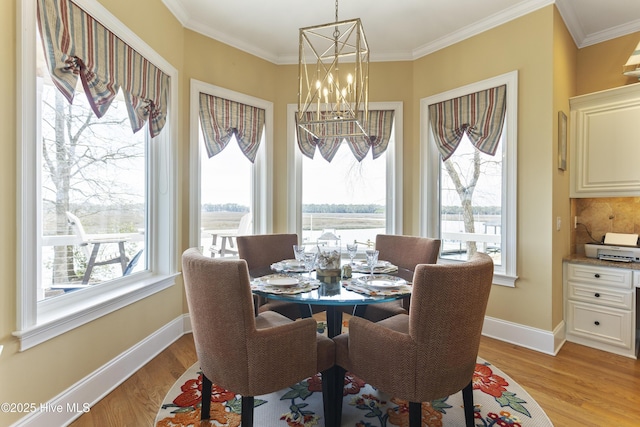 dining space with light wood-type flooring, baseboards, and ornamental molding