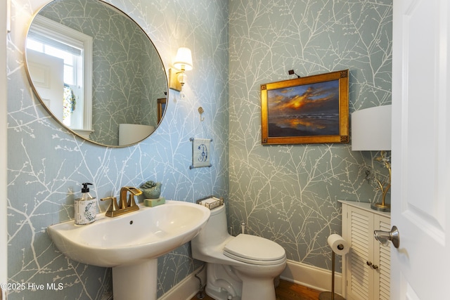 bathroom featuring wallpapered walls, toilet, and baseboards