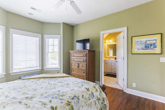 bedroom featuring visible vents, wood finished floors, connected bathroom, baseboards, and ceiling fan