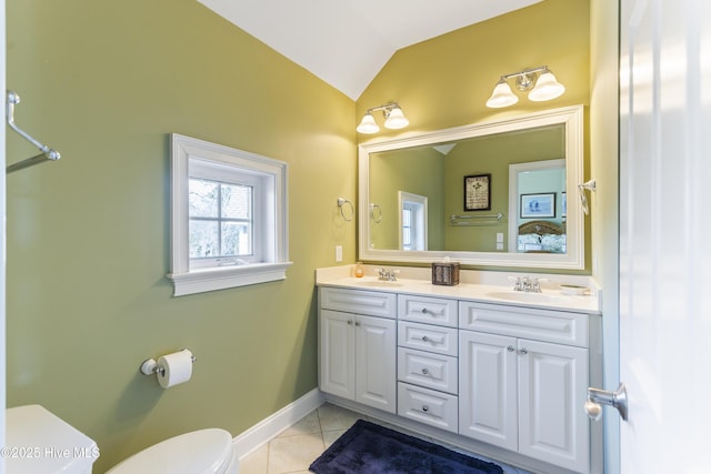 full bathroom featuring toilet, lofted ceiling, double vanity, tile patterned floors, and a sink