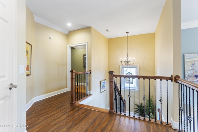 hallway featuring visible vents, an upstairs landing, a notable chandelier, wood finished floors, and baseboards