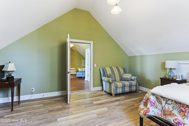 bedroom featuring baseboards, wood finished floors, and vaulted ceiling