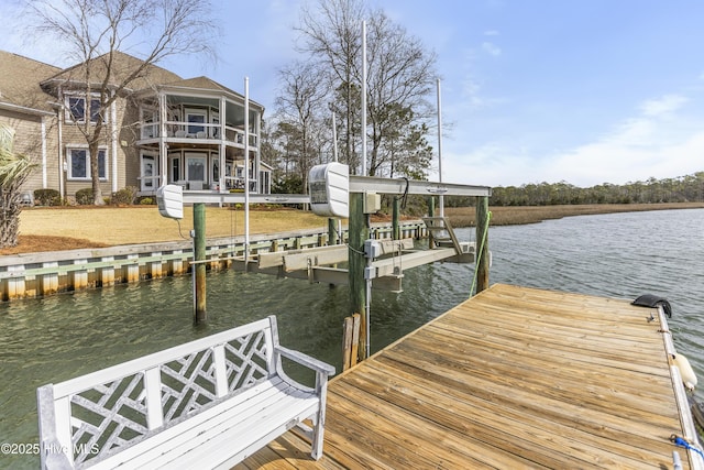 dock area featuring boat lift, a balcony, and a water view