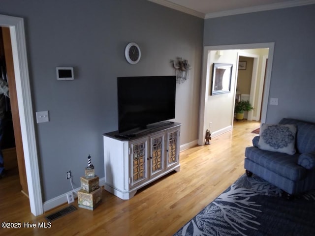 living area featuring ornamental molding, visible vents, baseboards, and wood finished floors