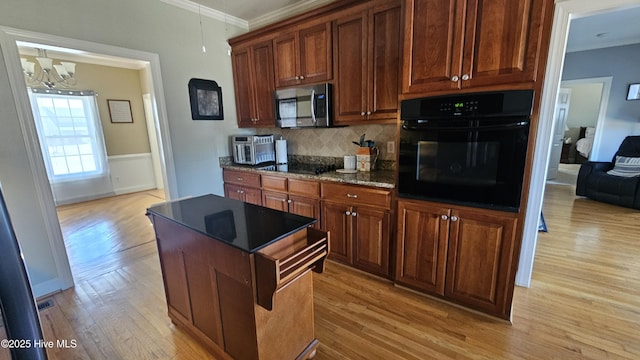 kitchen featuring tasteful backsplash, black appliances, ornamental molding, and light wood-style floors