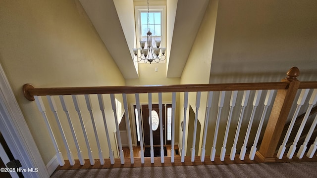 stairway featuring a notable chandelier