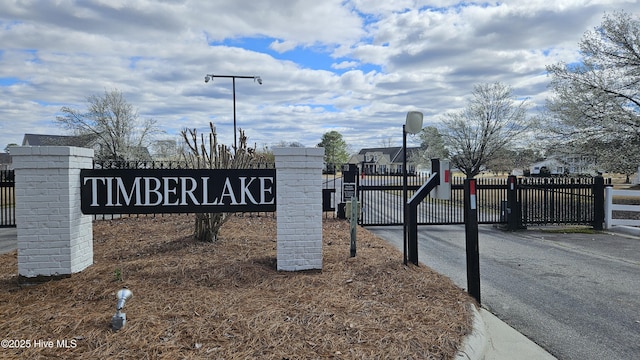 community / neighborhood sign with fence