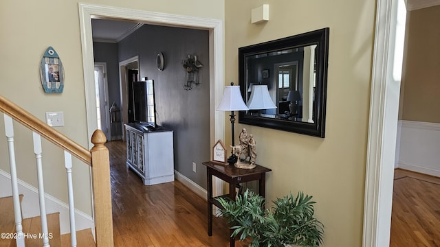 hallway with stairs, baseboards, wood finished floors, and crown molding