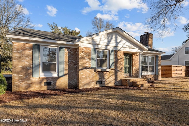 view of front of home featuring brick siding, a chimney, crawl space, fence, and a front lawn