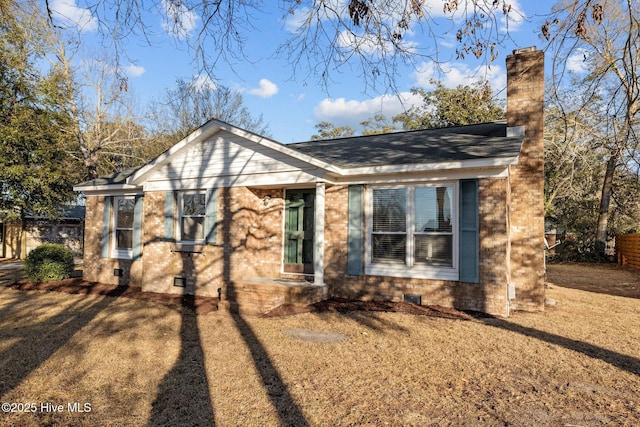 view of front facade featuring crawl space, a shingled roof, a chimney, and brick siding