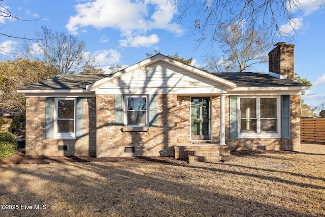 view of front facade featuring crawl space, a chimney, fence, and brick siding