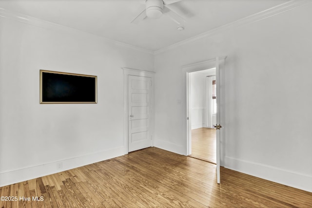 empty room with ornamental molding, baseboards, ceiling fan, and hardwood / wood-style flooring
