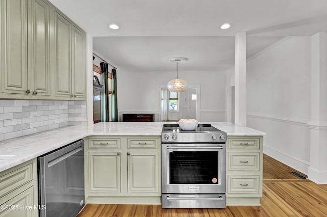 kitchen featuring tasteful backsplash, light stone countertops, light wood-style flooring, a peninsula, and stainless steel appliances