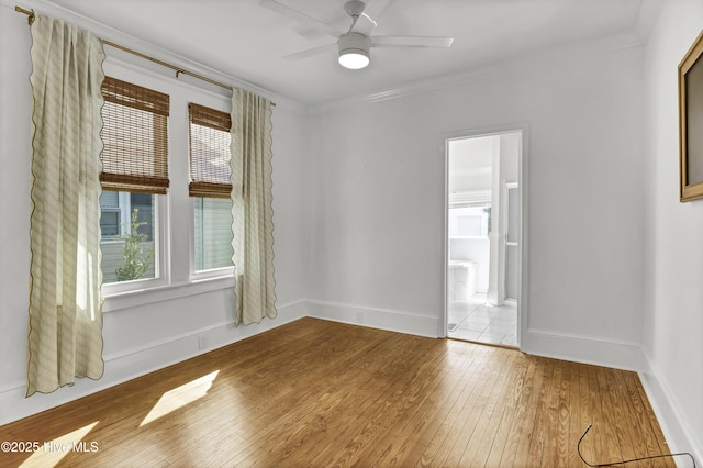 unfurnished room with hardwood / wood-style floors, ceiling fan, baseboards, and ornamental molding