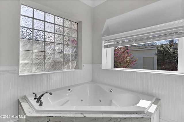 bathroom with a tub with jets and a wealth of natural light