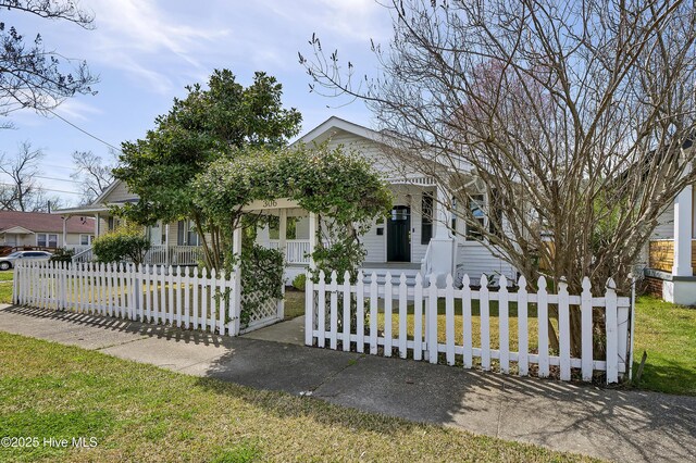 view of front of house with a porch, a front yard, and a fenced front yard