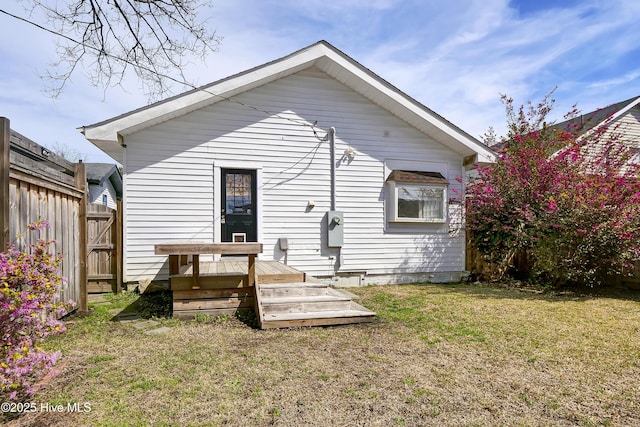 back of house featuring a deck, a yard, and fence