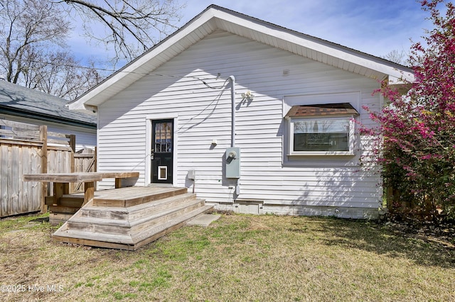 rear view of house with a yard and fence