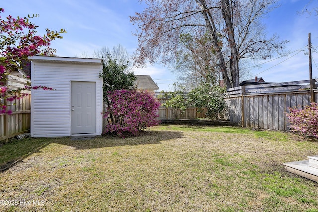 view of yard featuring an outbuilding, a storage shed, and a fenced backyard