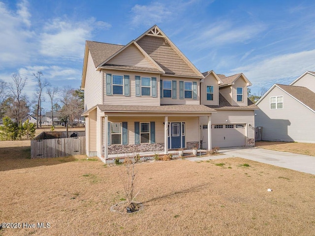 craftsman-style home featuring a porch, concrete driveway, an attached garage, fence, and a front lawn