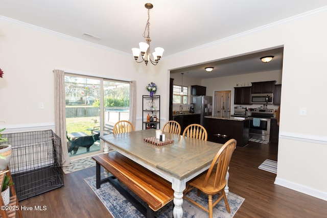 dining space with visible vents, baseboards, ornamental molding, dark wood finished floors, and an inviting chandelier