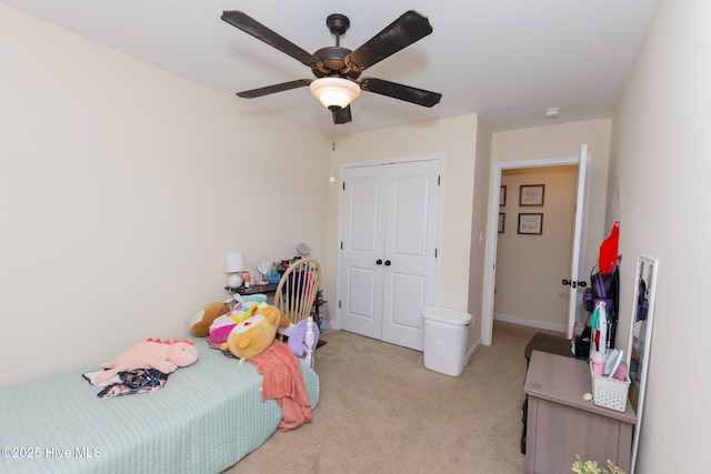 bedroom with a closet, a ceiling fan, and light colored carpet