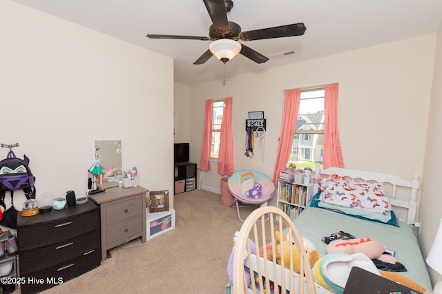 bedroom featuring ceiling fan, visible vents, and light colored carpet