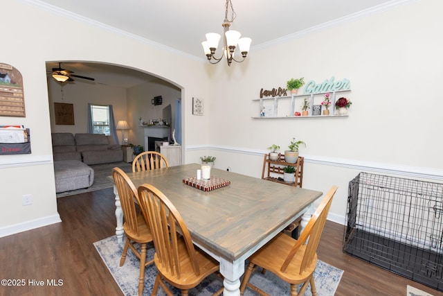 dining room featuring crown molding, arched walkways, and wood finished floors