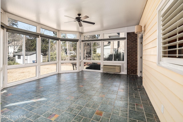 unfurnished sunroom with an AC wall unit, plenty of natural light, and a ceiling fan