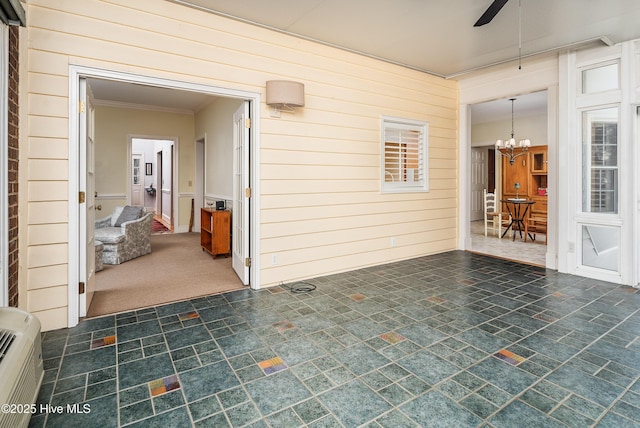 interior space featuring ceiling fan with notable chandelier