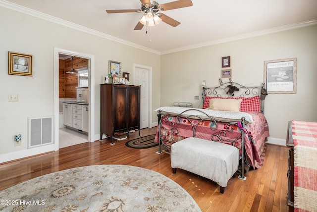 bedroom featuring visible vents, crown molding, baseboards, and hardwood / wood-style flooring