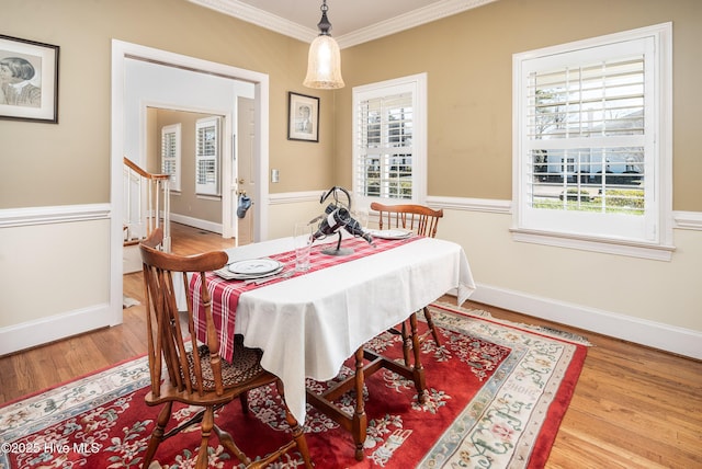 dining space featuring baseboards, stairway, crown molding, and wood finished floors