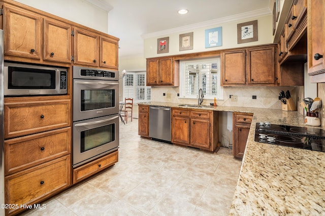 kitchen featuring brown cabinets, stainless steel appliances, decorative backsplash, ornamental molding, and a sink